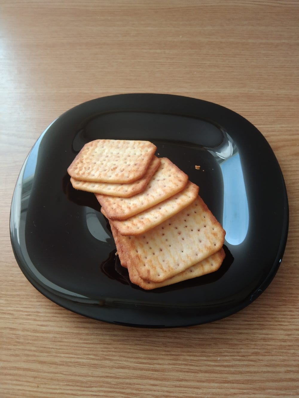 salty crackers black plate on a table